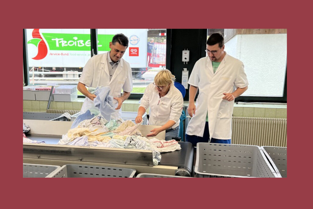 Bürgermeister Andreas Liebl sortiert mit zwei Mitarbeitern der KJF Werkstätte Mitterfels Wäsched