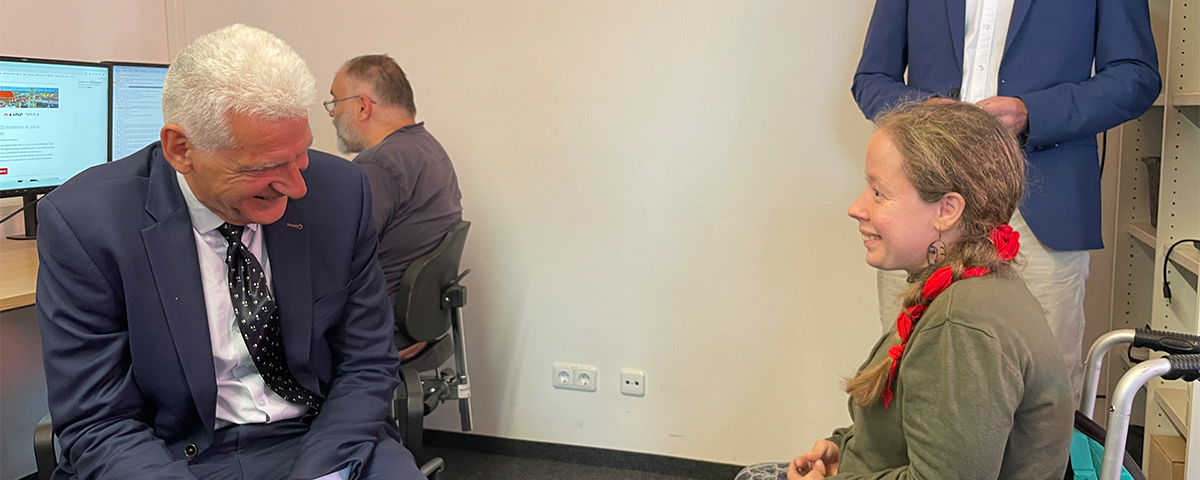 Staatssekretär Dr. Rolf Schmachtenberg im Gespräch mit Mitarbeiterin der St. Johannes Werkstätte Regensburg.