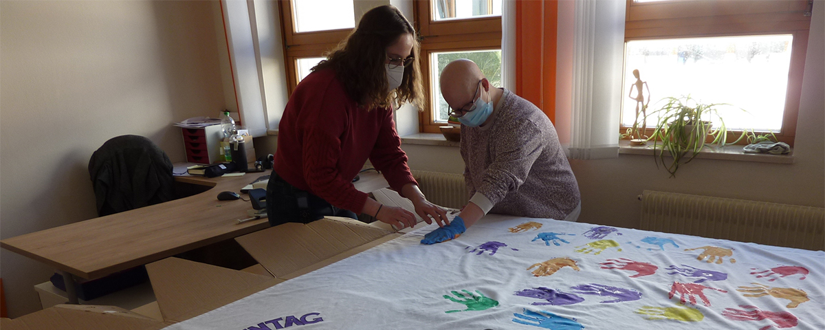 Eine Leinwand mit bunten Handabdrücken, gestaltet im Rahmen einer Aktion der Frauenbeauftragten.