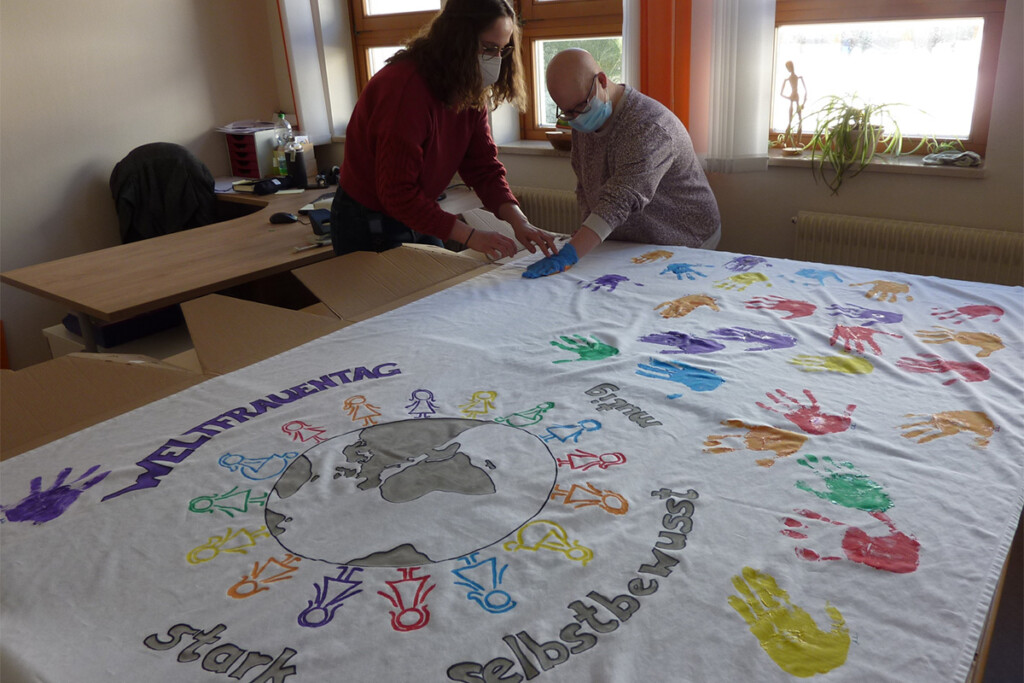 Eine Leinwand mit bunten Handabdrücken, gestaltet im Rahmen einer Aktion der Frauenbeauftragten.