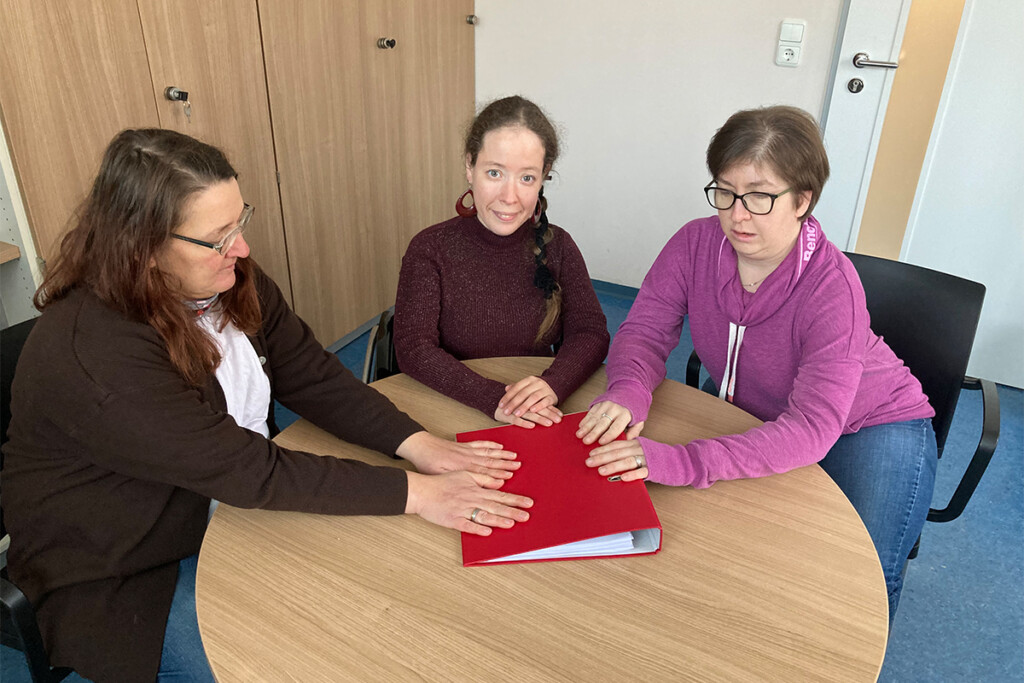 Die drei Frauenbeauftragten sitzen zusammen an einem runden Tisch.