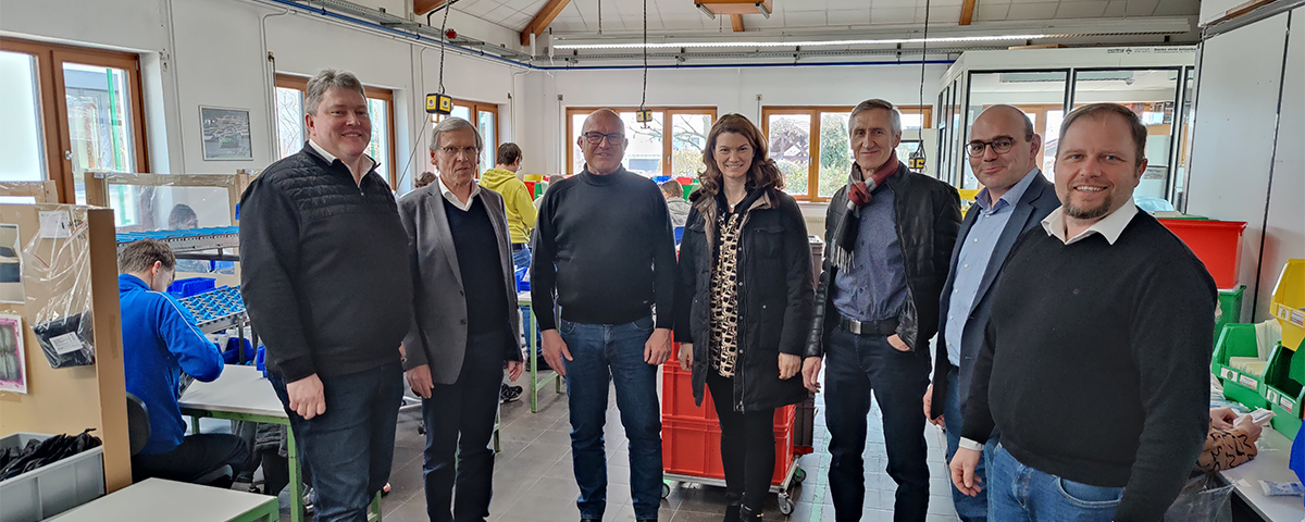 Die Politiker der Freien Wähler stehen zusammen mit Herrn Dr. Kick in einem Produktionsraum.