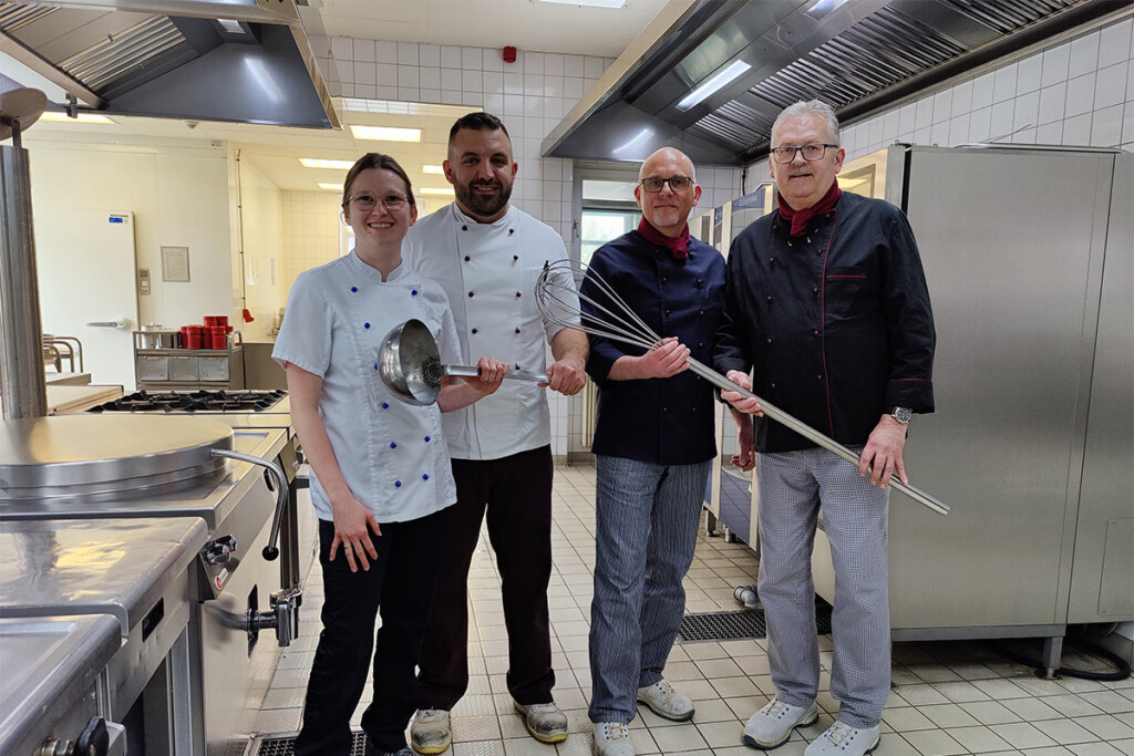 Das Küchenteam übergibt die Kelle in der Küche.
