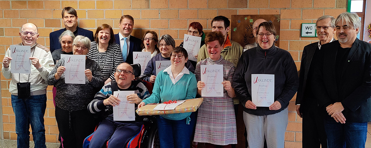 Gruppenfoto der geehrten Mitarbeiterinnen und Mitarbeiter mit ihren Urkunden