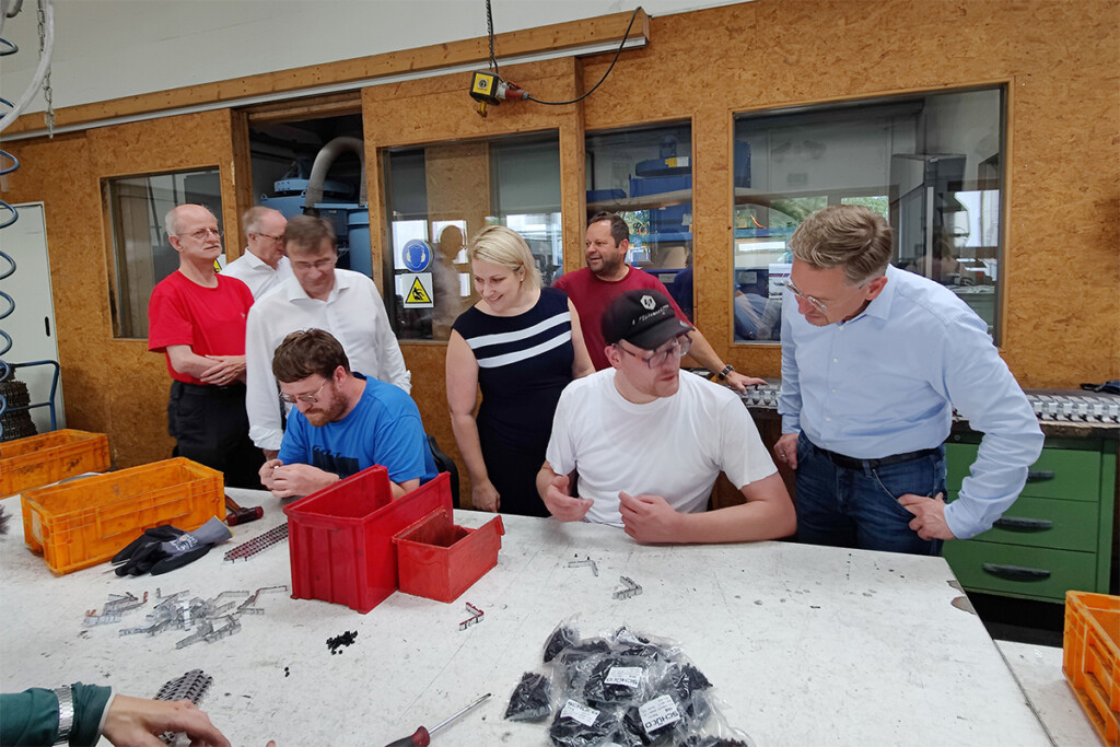 Tobias Reiß mit Mitarbeitern an ihrem Arbeitsplatz.