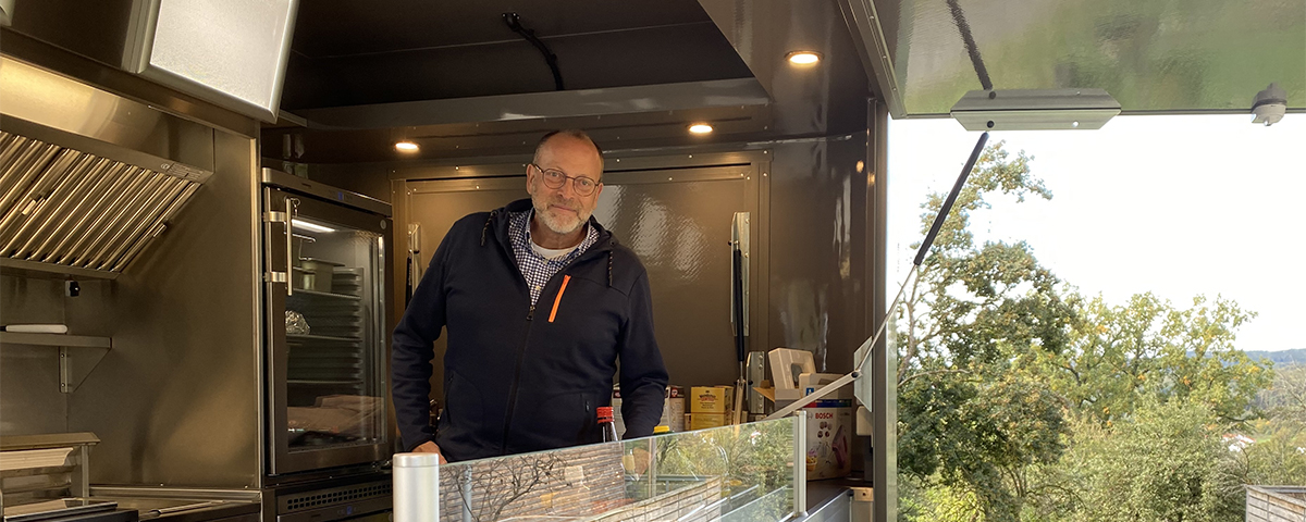 Standortleiter Bernd Röhrl blickt aus dem neuen Foodtrailer heraus.