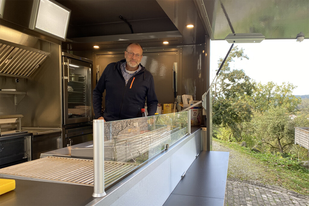 Standortleiter Bernd Röhrl blickt aus dem neuen Foodtrailer heraus.