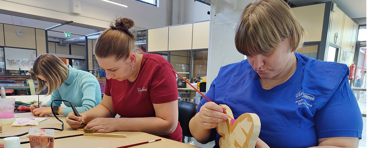 Mitarbeiter bemalen Holzschmetterling