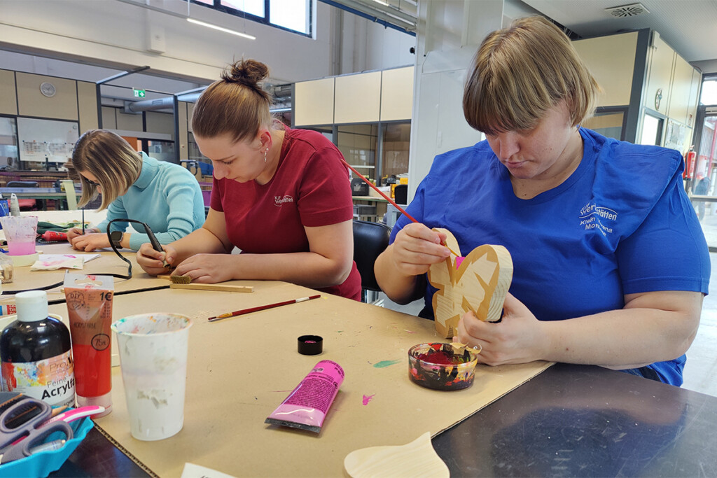 Mitarbeiter bemalen Holzschmetterling