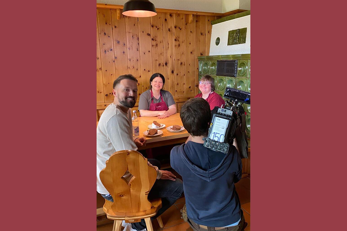 Mitarbeiter und Filmteam rund um einen Tisch