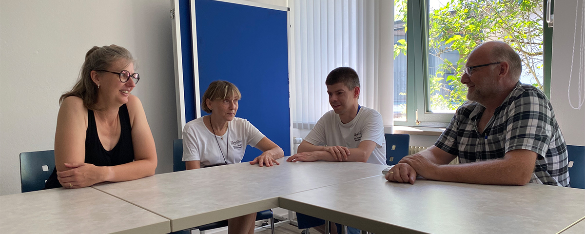 Vier Personen sitzen an einem Tisch