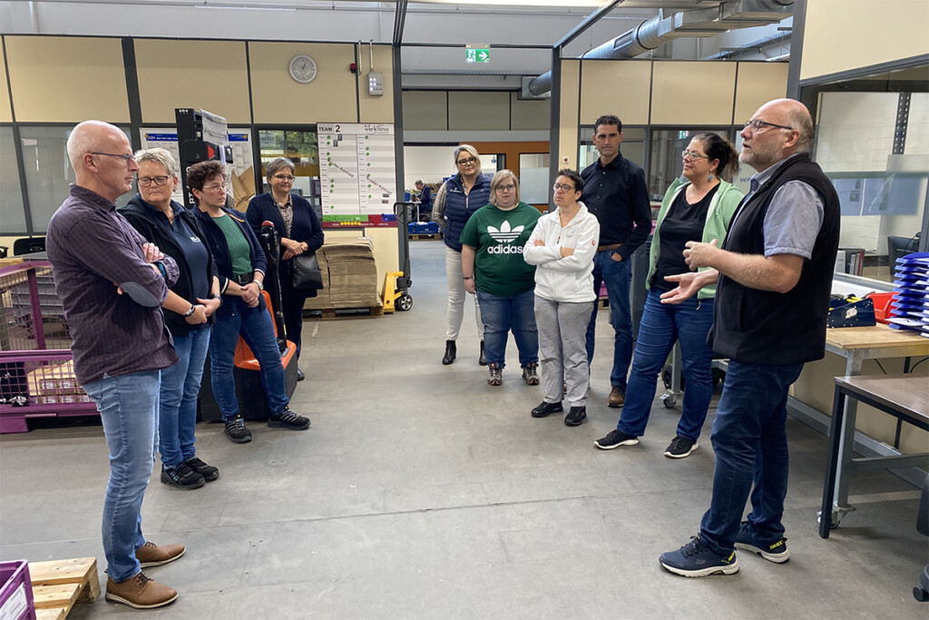 Erklärung in der Produktionsstätte. Mehrere Personen stehen im Kreis.
