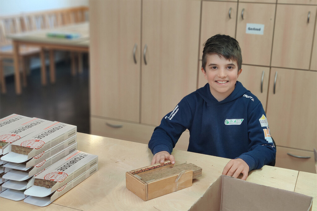 Ein Junge sitzt an einem Arbeitsplatz