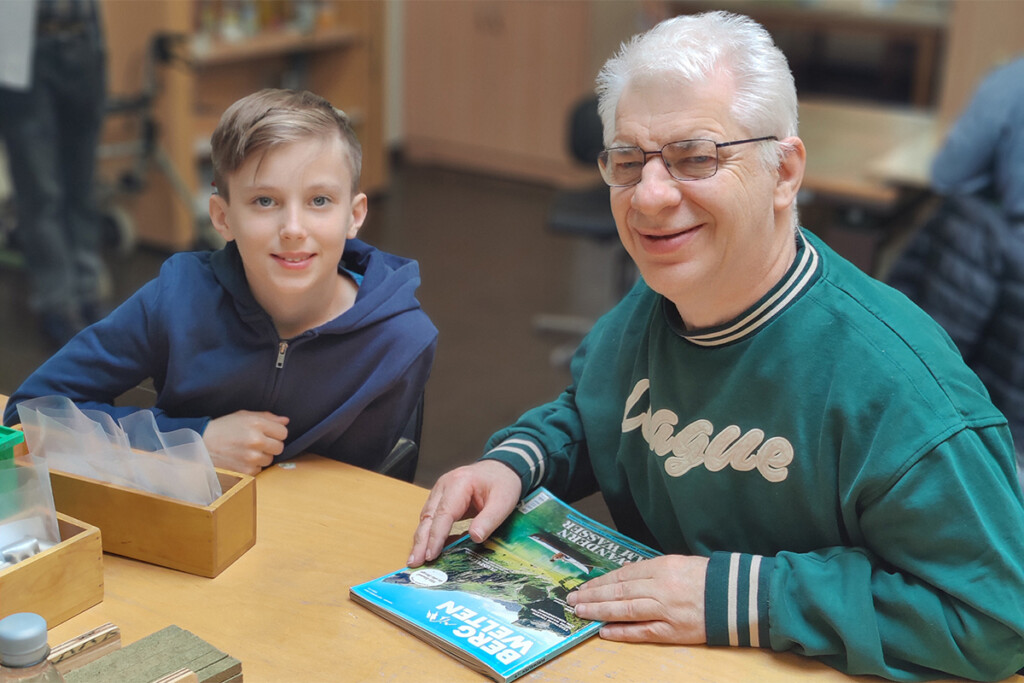 Ein Junge sitzt neben einem Mitarbeiter