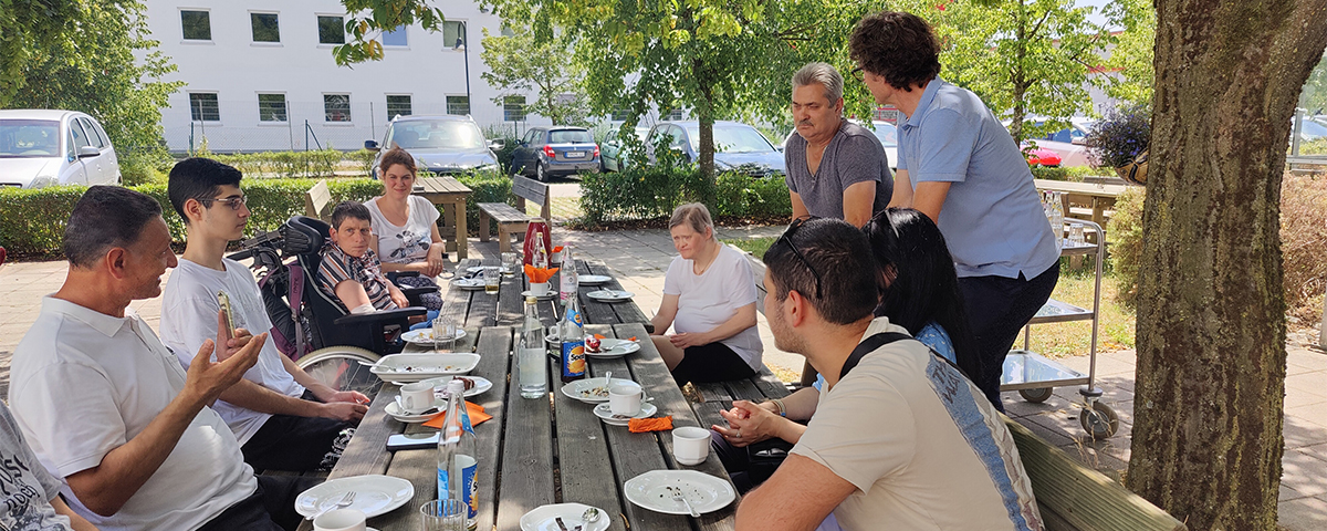 Alle sitzen an einem großen Tisch zusammen