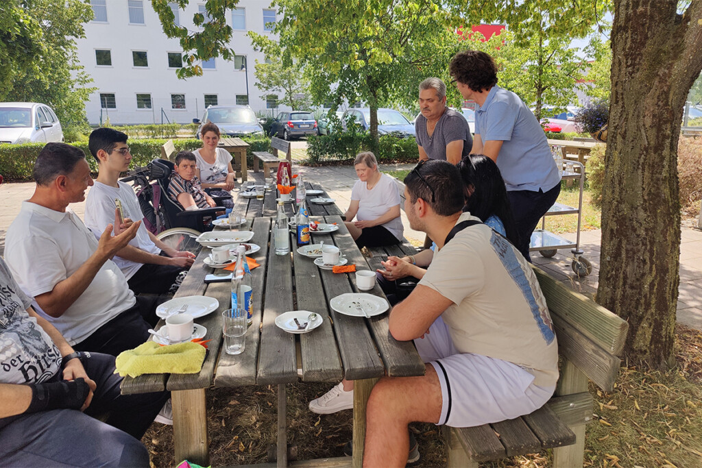Alle sitzen an einem großen Tisch zusammen