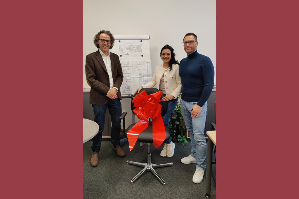 Firma Ottmar Heckl überreicht Bürostuhl mit roter Schleife.