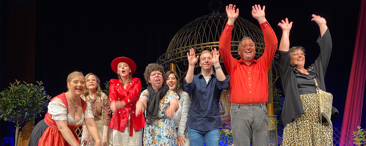 Die Models aus der Straubinger KJF-Werkstätte machen einen Laola-Welle auf der Bühne beim Schlagerwettbewerb Goldener Musistern.