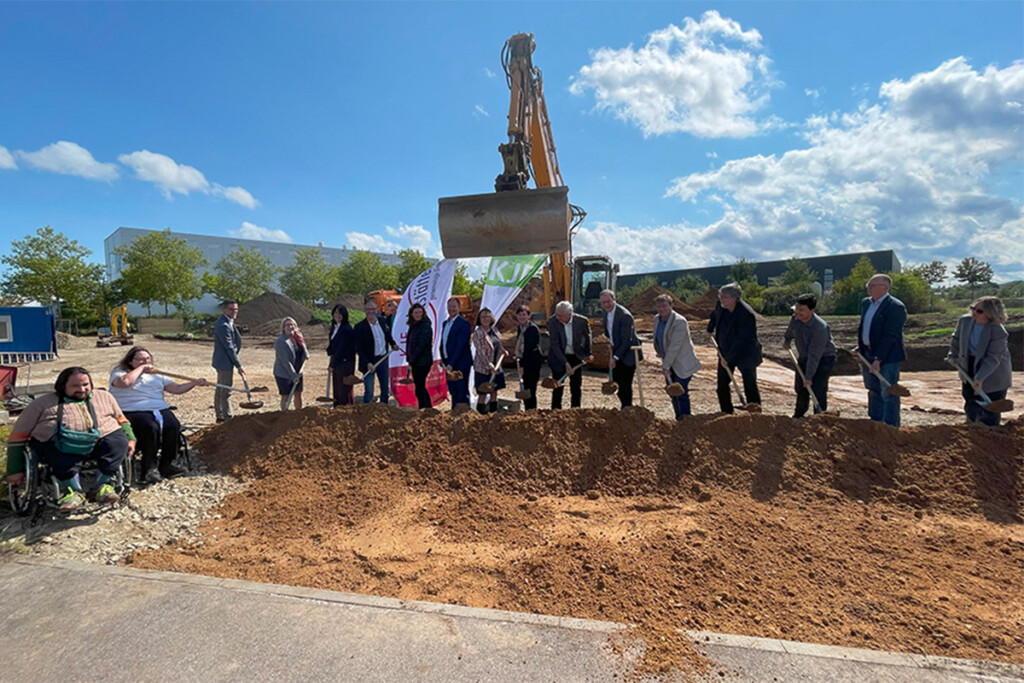 Die Gäste und Werkstätten-Mitarbeiter vollziehen den symbolischen Spatenstich.