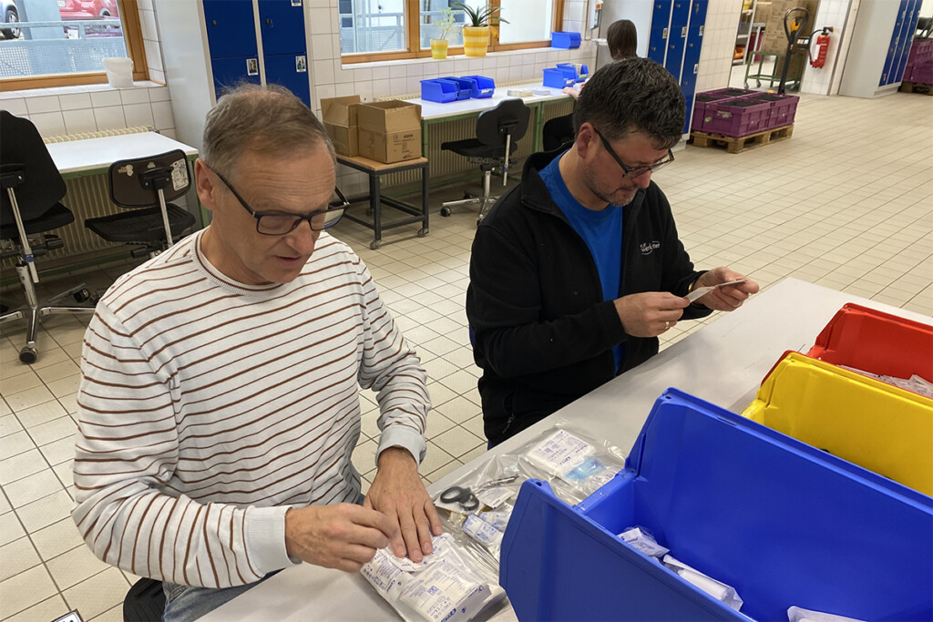 Waldsassens Bürgermeister Bernd Sommer (links) bestückt Verbandskasten mit einem Mitarbeiter der Werkstätte.