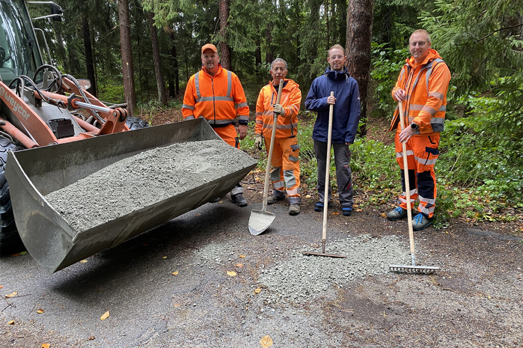 Marcel Hein, Mitarbeiter der Bruder Konrad Werkstätte, mit der Mitarbeitern des Bauhofs der Gemeinde Mitterfels. Sie sind dabei, Schlaglöcher auf einem Waldweg auszubessern.