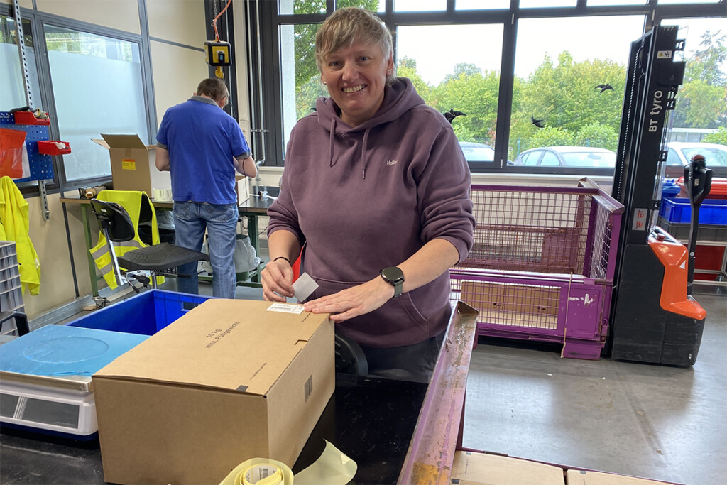 Eine Teilnehmerin des Schichtwechsels verpackt Autoteile.