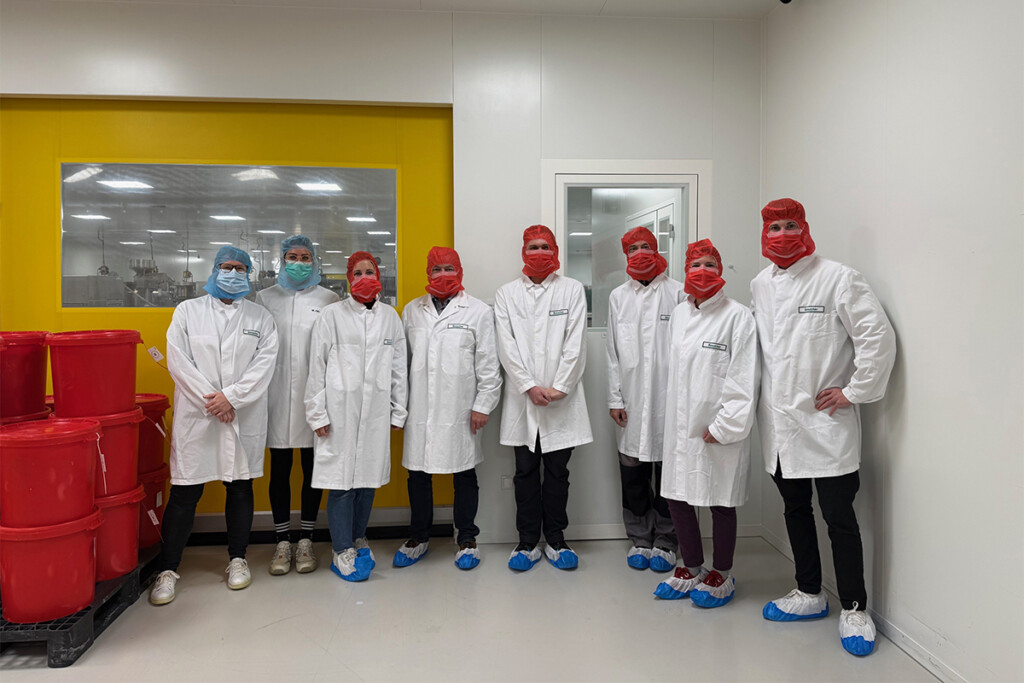 Die Gruppe aus den KJF Werkstätten steht im Produktionsbereich der Firma Vital Products. Alle tragen aus Hygienegründen Schutzkleidung.