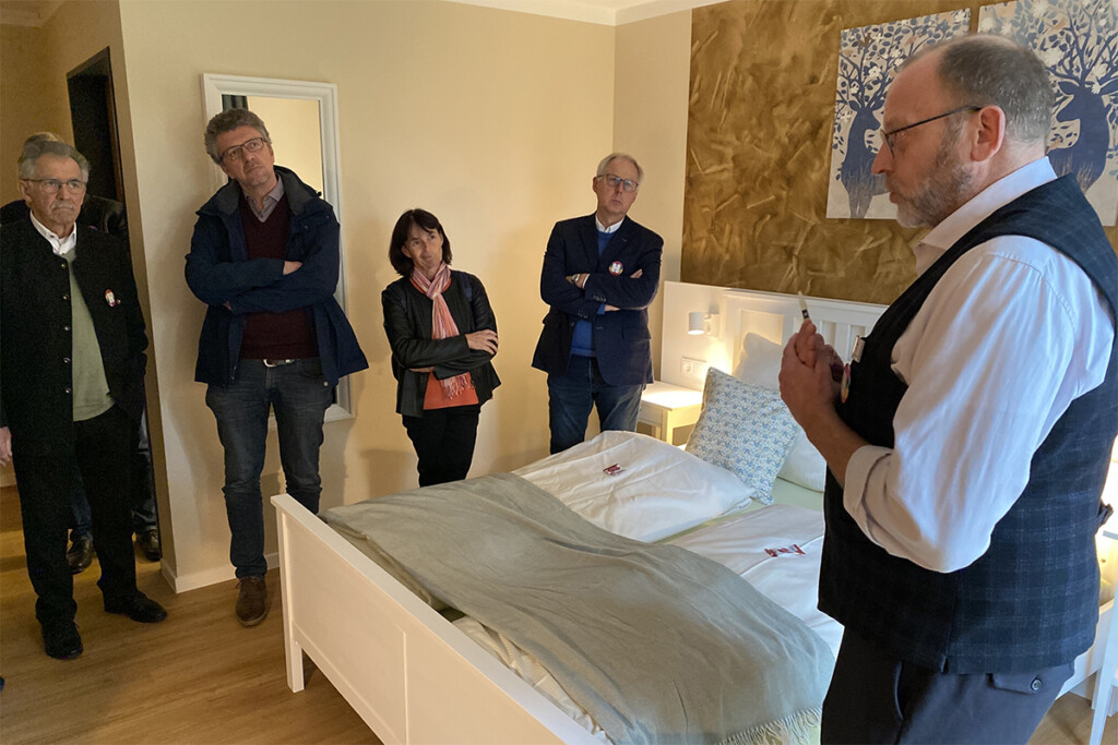 Standortleiter Bernd Röhrl und die Gäste in einem Gästezimmer