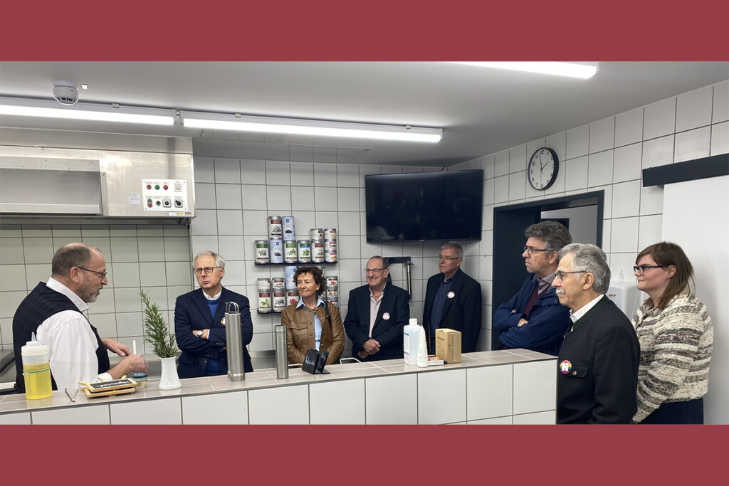 Standortleiter Bernd Röhr und die Gäste stehen in der Küche