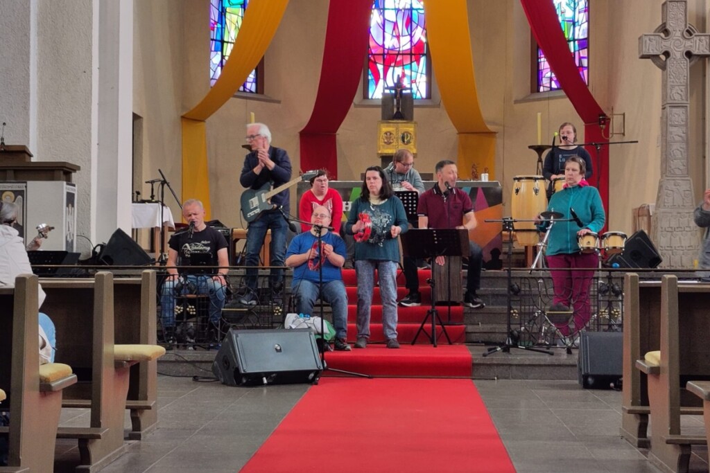 The Inclusions tritt beim Katholikentag in Würzburg im Altarraum einer Kirche mit Instrumenten und Gesang auf